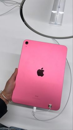 a person holding an apple ipad in their left hand, with the back cover removed