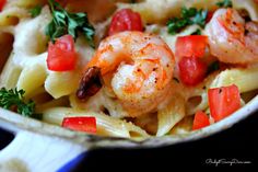 pasta with shrimp, tomatoes and parsley in a skillet ready to be eaten