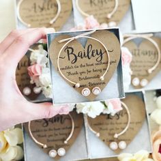 someone is holding up some heart shaped brooches in front of flowers and cards