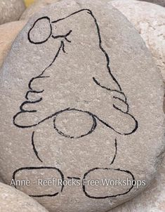 a rock with a drawing of a teddy bear on it's face is surrounded by rocks