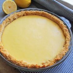 a lemon pie sitting on top of a blue and white checkered table cloth