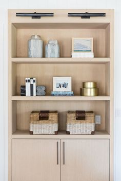 a book shelf with baskets and books on it