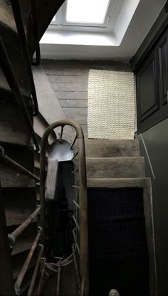 an old wooden staircase with a skylight above it