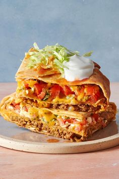 two quesadillas stacked on top of each other with lettuce and tomatoes