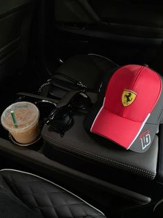 there is a red hat, coffee and other items in the car