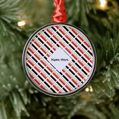 a personalized ornament hanging from a christmas tree with red and black stripes