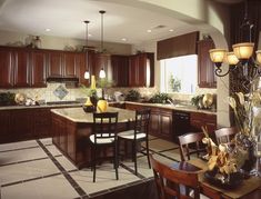 a kitchen filled with lots of wooden cabinets and counter top space next to a dining room table