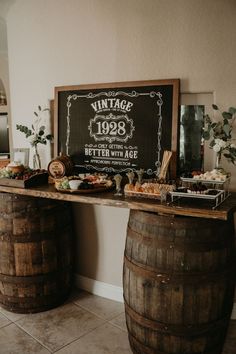 an old fashioned bar is set up with wine barrels and snacks on the table for guests to eat