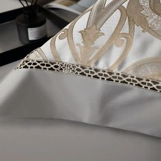 a close up view of a white and gold comforter with decorative designs on it