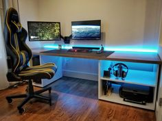 a computer desk with headphones on it in front of a television and monitor screen