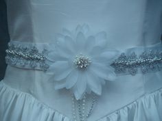 Beautifully hand stitched sash adds beauty to your bridal gown not bulk to your waist Great price Satin ribbon sash 108'' long and 1.5'' wide, it does not add bulk to your waist at all! It embellishes any white bridal gown! Description: White sash with faux white silk flower, Beautiful silver trim, white and silver pearls are twisted and securely sewn on sash. Flower has sliver crystals center. Please look at all the pictures, although, they don't do justice to the actual beauty of this gorgeous Silver Bridesmaid Sashes Bridal Accessories, White Bridal Belt With Ribbon For Wedding, Elegant Bridal Belt With Handmade Flowers For Weddings, White Embellished Sashes For Wedding, White Bridal Gown, Wedding Dress Belt, Wedding Sash Belt, Silver Lace, Bride Accessories