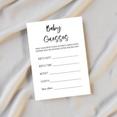 a baby guess card sitting on top of a sheet of white paper with black writing