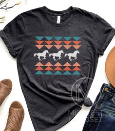 A Native American inspired TShirt featuring a horse. Aztec Horse Shirt Horse Lover Shirt Western Tee Country Girl Native American Free Spirit Southwest Horse Riding Rider Tee Bellas Canvas 3001T:  T-Shirt Sizing Please reference the size chart before selecting shirt size.  Use one of your own t-shirts to measure the size and fit.  Then compare with the size chart provided to ensure an accurate fit. T-Shirt Materials 100% combed and ring-spun cotton. Heather colors are 90% combed and ring-spun co Casual Short Sleeve Tops With Horse Design, Short Sleeve Cotton Top With Horse Design, Cotton Short Sleeve Top With Horse Design, Cheap Fitted Western Style T-shirt, Cheap Western Style T-shirt For Rodeo, Native American Shirts Graphic Tees, Horse Graphic Tee, Native Ameriv Can Horses T Shirt, Casual Short Sleeve T-shirt With Horse Design