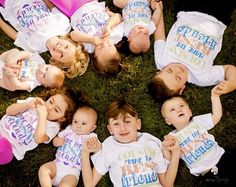 a group of children laying on the ground together wearing shirts that say happy little unicorns