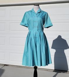 "Who doesn't love a vintage Sears dress? This beauty is a lovely light blue shirt dress with a double breasted front panel with topstitching detail.  This would make a lovely every day dress, or it is perfect for an Alice in Wonderland vintage look or cosplay!! Beautiful pleating on the skirt, original thread belt loops are still on the dress, but the original belt is not included. It would look great with any number of other belts, so many colors would go beautifully with this blue!  Front butt Classic Vintage Dress With Buttons For Spring, Classic Blue Shirt Dress With Buttons, 1950s Style Vintage Dress For Spring Workwear, Fitted Retro Shirt Dress For Summer, Classic Blue Shirt Dress For Summer, Classic Blue Dress For Vintage Fashion, Fitted Retro Shirt Dress For Daywear, Fitted Vintage Shirt Dress With Short Sleeves, Blue Vintage Dress With Buttons For Spring