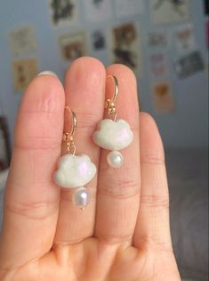 a person holding two small white pearls in their hand