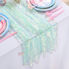 the table is set with plates, napkins and other decorative items in pastel colors