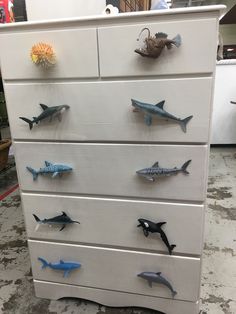 a white dresser with shark magnets on it