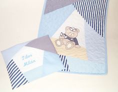 two blue and white baby blankets with a teddy bear on them, one is laying down