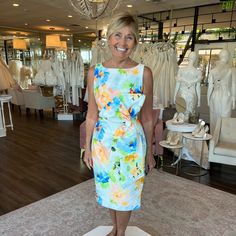 a woman standing in front of a display of dresses