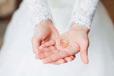 a person holding two wedding rings in their hands