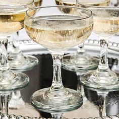 several glasses of wine sitting on top of a silver tray