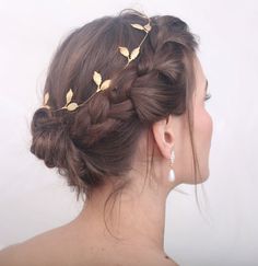 a woman wearing a gold leaf head piece