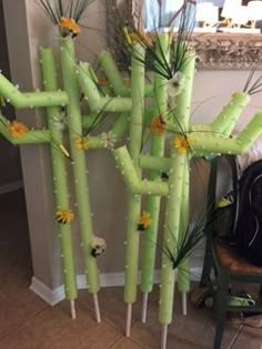 a bunch of sticks with flowers on them in the middle of a room next to a mirror