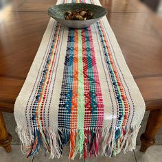 a table with a bowl on top of it next to a wooden dining room table