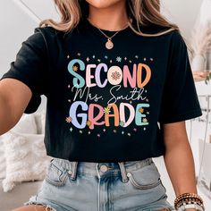 a woman wearing a black t - shirt that says second grade