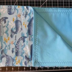 two pieces of blue fabric sitting next to each other on top of a cutting board