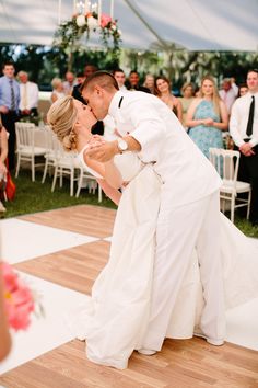 a bride and groom kissing on the dance floor