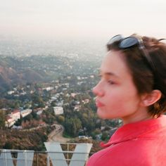 a woman with sunglasses on top of a hill