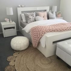 a white bed sitting in a bedroom on top of a rug