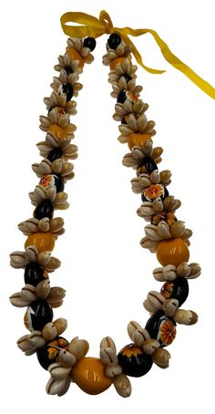 an orange and black beaded necklace on a white background with a yellow ribbon around it