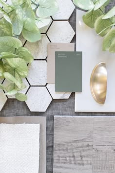 a table topped with lots of different types of paint and decorating items next to a potted plant