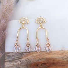 Gorgeous statement earrings featuring gold arch adorned with sparkly crystals. Wear it to your wedding or bridal shower for a unique and modern look. They are the perfect bridal earrings for those who want something as unique and different.Dance the night away with confidence as these gold arch earrings are lightweight and comfortable and the crystal stones catch the light and sparkle brilliantly.✨Suggested occasion for wear: your wedding, wedding guest, bridal shower, prom, gala events, wedding Sparkly Crystals, Arch Earrings, Gala Events, Gold Statement Earrings, Wedding Rehearsal Dinner, Wedding Rehearsal, Crystal Stones, Seasonal Gifts, Bridal Earrings