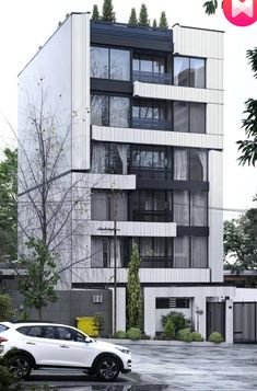 a white car parked in front of a tall building