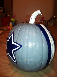 a large white pumpkin with a blue star painted on it's side sitting on a table