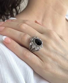 Experience the beauty of handcrafted jewelry with this exquisite embroidery ring. Made with the highest quality materials, the 925 sterling silver band is designed with filigree art and oxidized for an antique look. The 10x12 mm cabochon oval cut Black Onyx gemstone is set in a bezel setting, adding a touch of luxury and sophistication to any outfit. Measuring 0.9 inches / 22.50 mm in length and 0.80 inches / 20.00 mm in width, this ring features intricate filigree details that showcase the arti Luxury Sterling Silver Gemstone Dome Ring, Traditional Black Filigree Jewelry, Black Sterling Silver Filigree Ring As A Gift, Ornate Black Sterling Silver Rings, Ornate Black Rings As Gift, Ornate Black Rings For Gifts, Ornate Black Rings For Gift, Black Ring With Intricate Design, Black Oxidized Rings For Anniversary