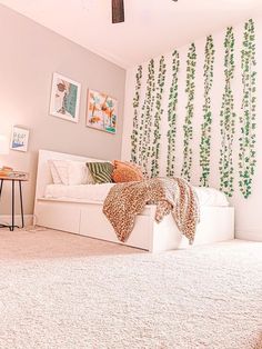 a bedroom with white carpet and green plants on the wall