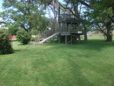 a tree house in the middle of a grassy field