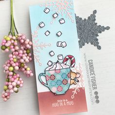 a close up of a card on a table with some flowers and candy canes