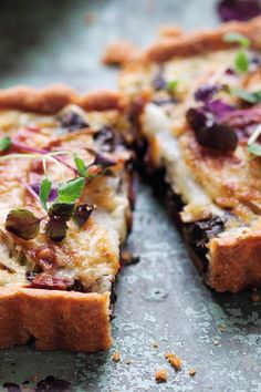 a close up of a pizza with toppings on a table next to a slice missing