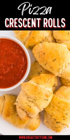 a white plate topped with pizza crescent rolls next to a bowl of marinara sauce