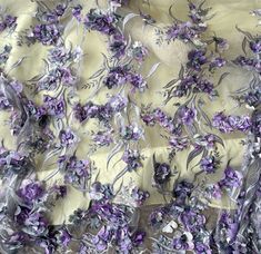 purple flowers and leaves are on the sheered fabric that has been sewn together