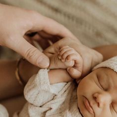 a newborn baby is being held by someone's hand