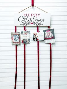 a merry christmas sign hanging from the side of a wall with pictures and ribbons attached to it