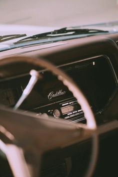 an old car dashboard with the radio and steering wheel visible in sepia - toned photograph