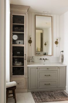 a bathroom with a large mirror, sink and cabinet in it's center area